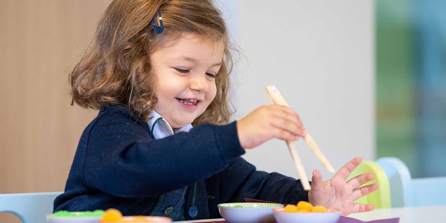 Bright young girl enjoying an educational activity in a world schools classroom, engaging in hands-on learning.