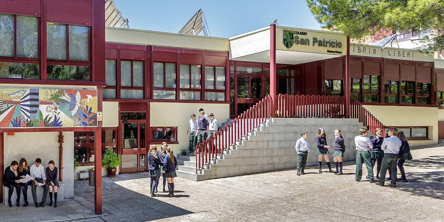 Modern school building with students engaging outside, highlighting quality education and campus environment.