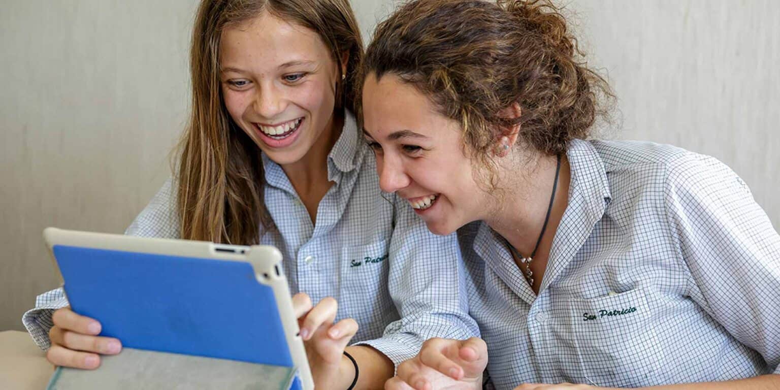 Happy students engaging with digital learning at World Schools.