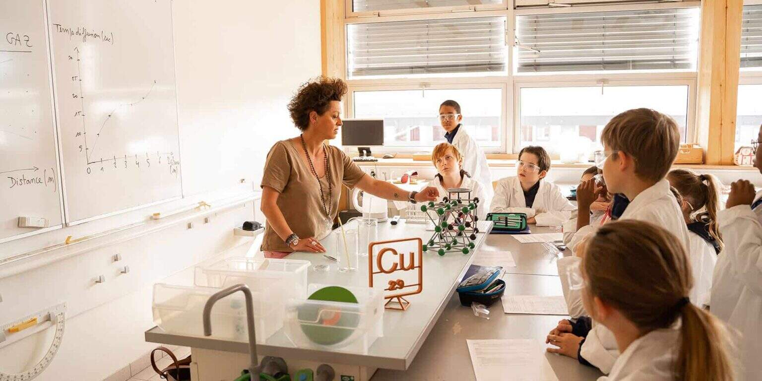 Engaging classroom scene at a top international school, highlighting science experiments and active student participation.