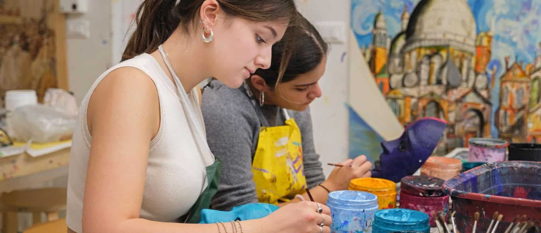 Bright female students engaging in visual arts at a worldwide school, fostering creativity and global education.