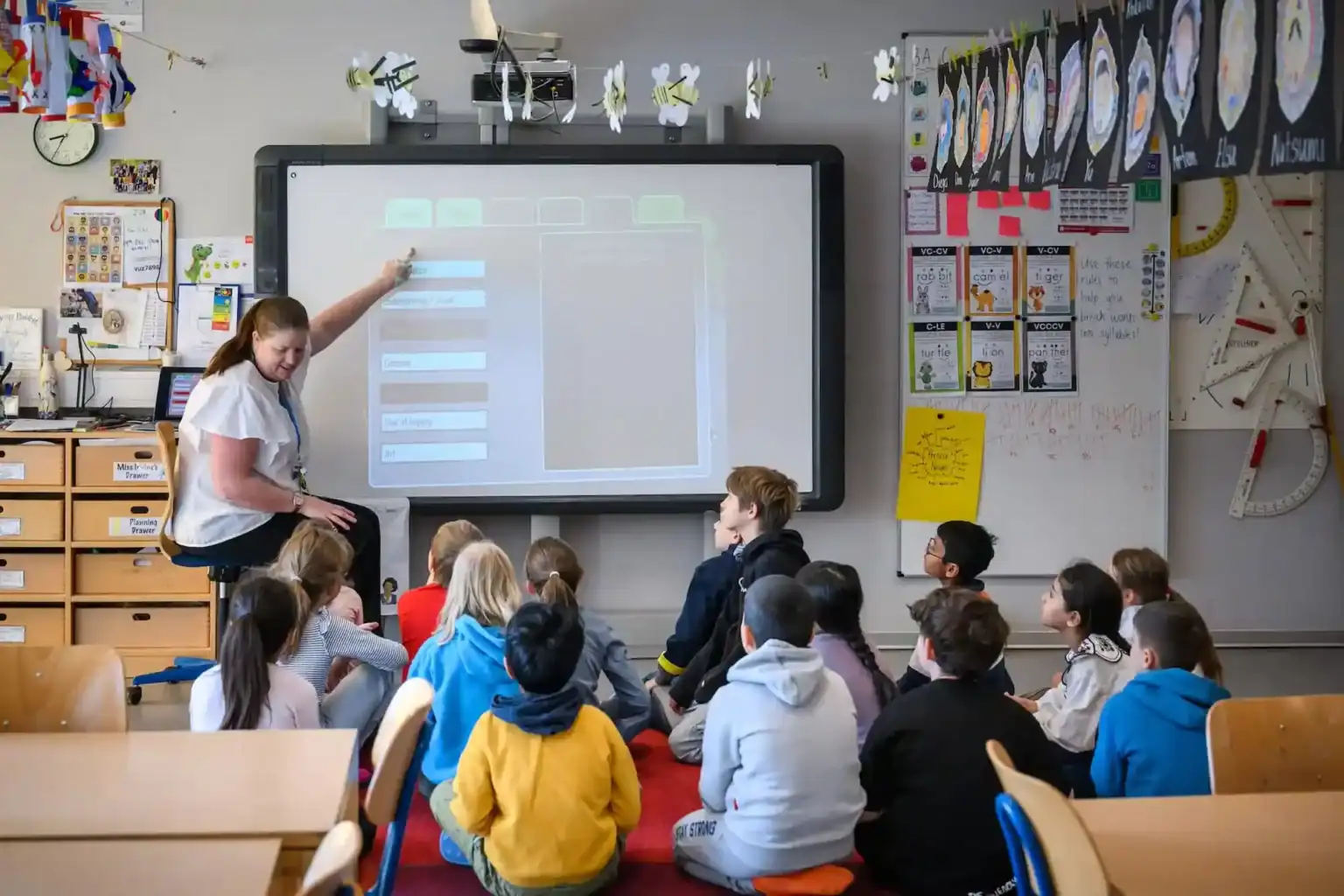 Bright classroom with diverse students learning with digital interactive smartboard at World Schools.