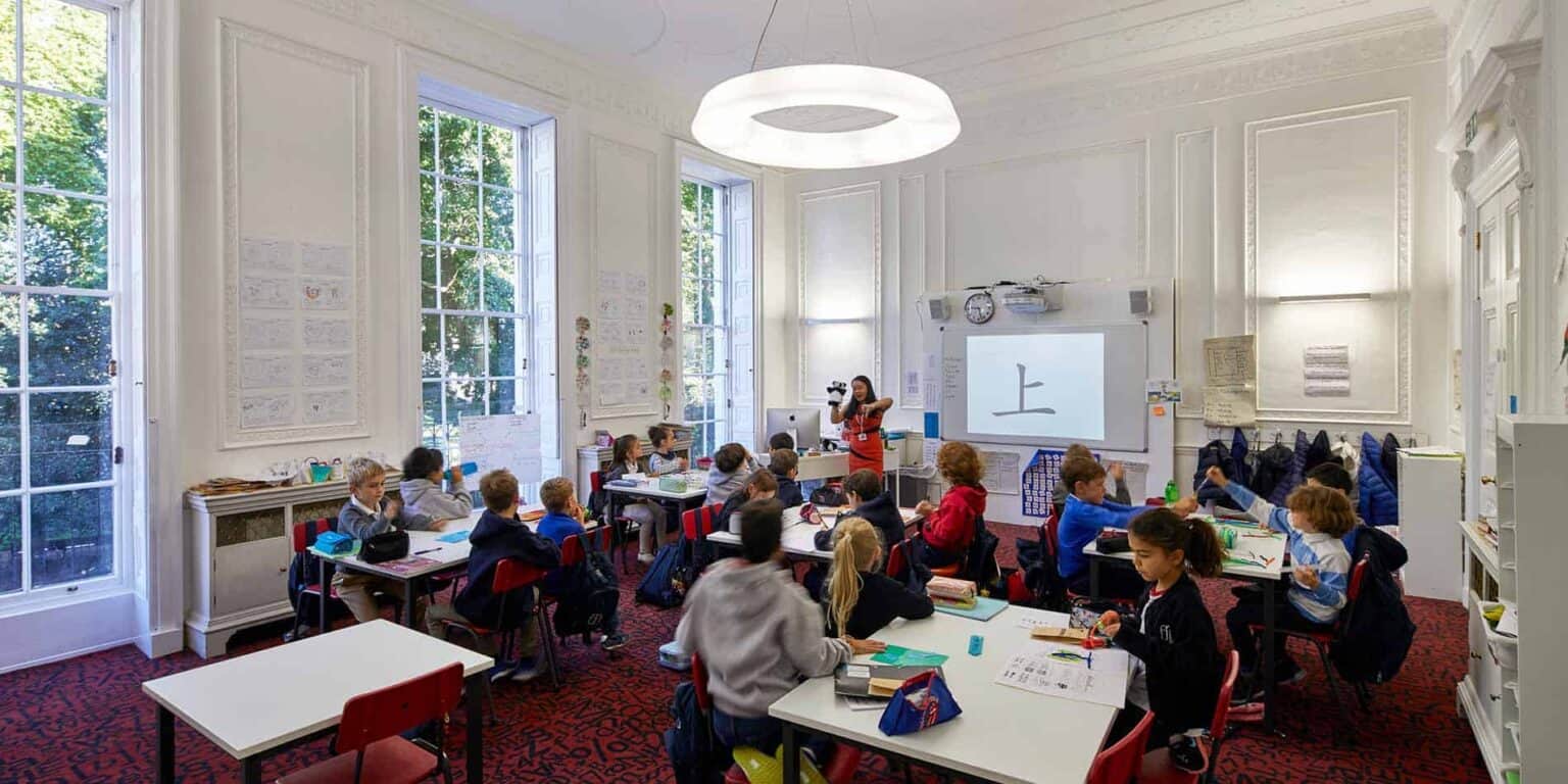 Bright classroom with young students learning Chinese language in elegant, spacious school environment.