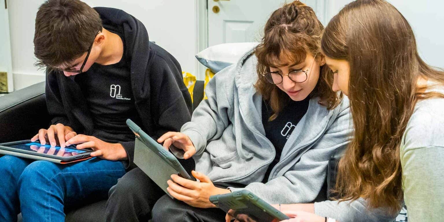 Students using tablets and smartphones during classroom activity at World Schools.