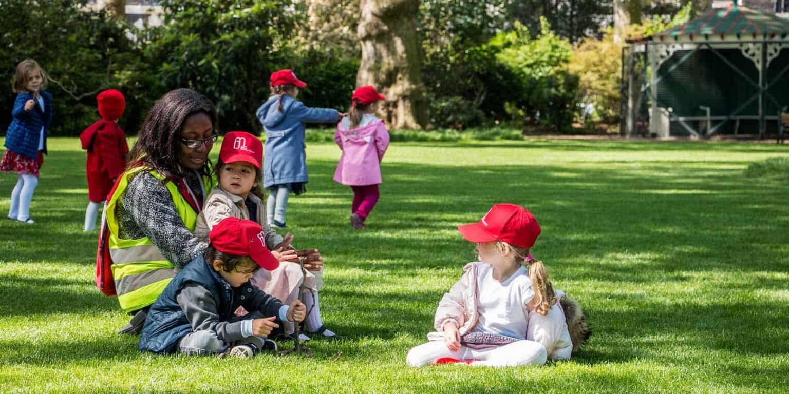 Children playing outdoors at a world school, engaging in fun and educational activities on lush green grass.