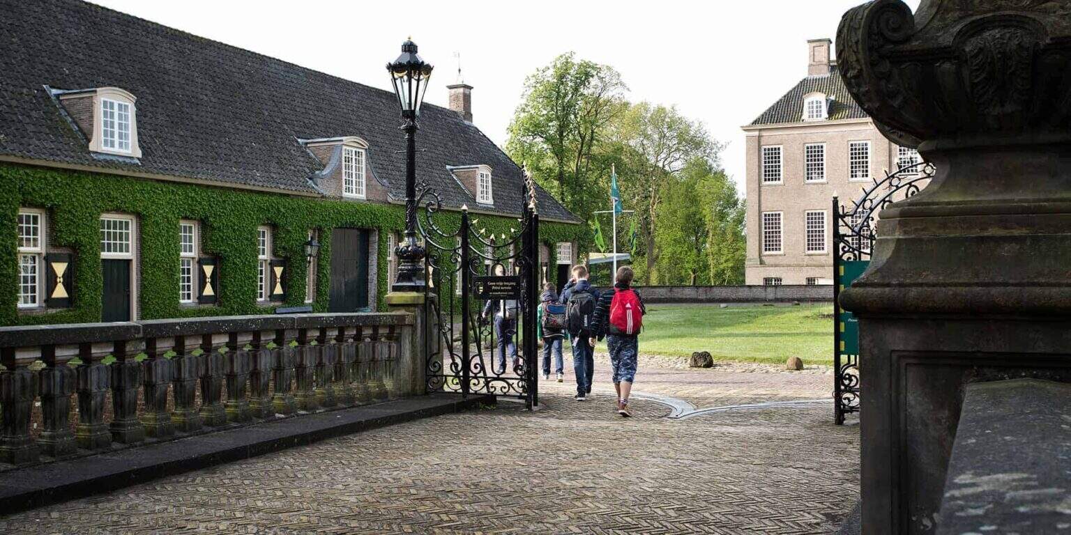 Students entering a prestigious green campus school, emphasizing world-class education and global learning environments.