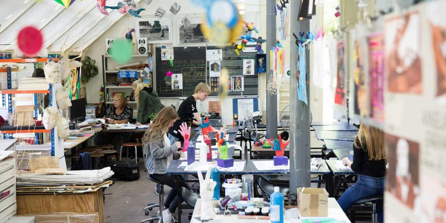 Colorful art classroom with students creating crafts and engaging in creative activities at a world school.