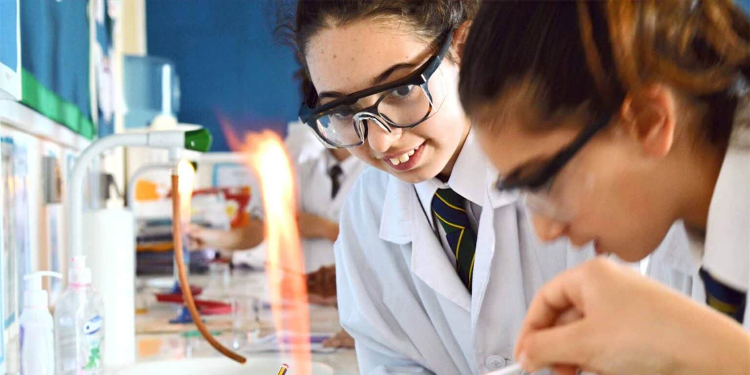 Girls conducting science experiments in a school laboratory, focusing on STEM education at world schools.