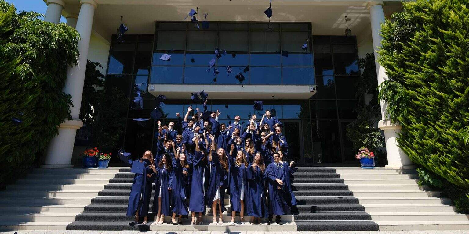 Graduates throwing caps during graduation ceremony at World Schools international school.