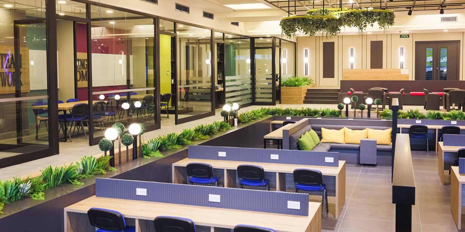 Bright modern school interior with study areas, lush greenery, and advanced facilities for student learning and collaboration.