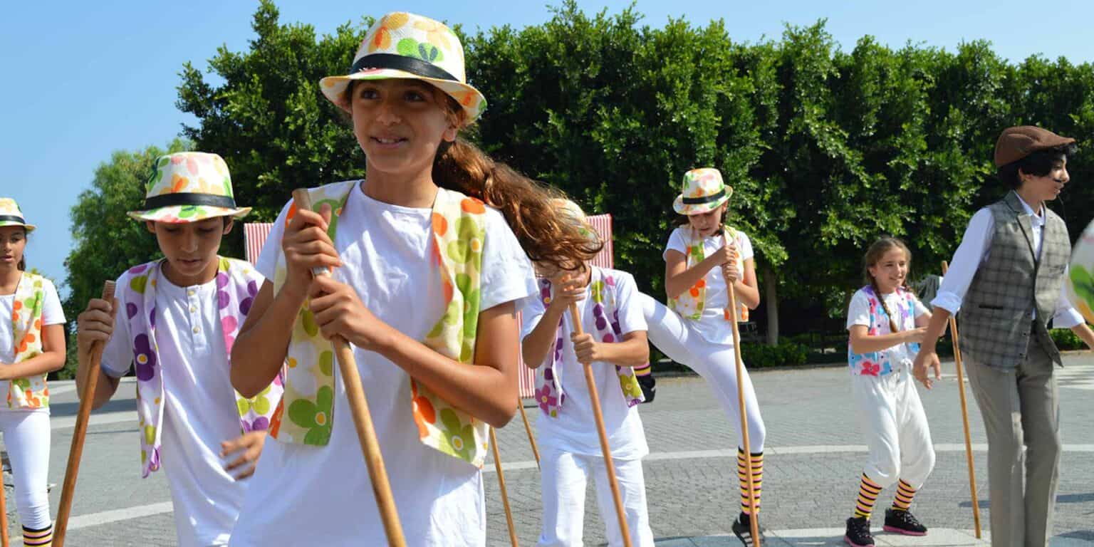 Colorful school children participating in outdoor activities at World Schools event.