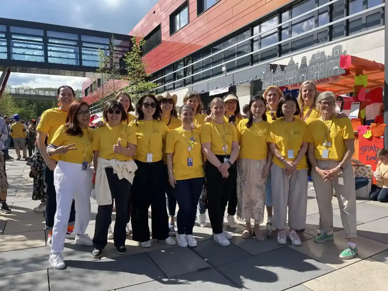 Volunteers at World Schools event promoting global education and cultural exchange, wearing matching yellow shirts for teamwork.