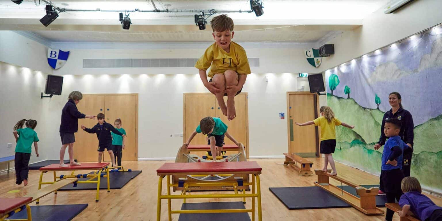 Kids engaging in physical activities at a modern indoor school gymnasium, emphasizing active learning.