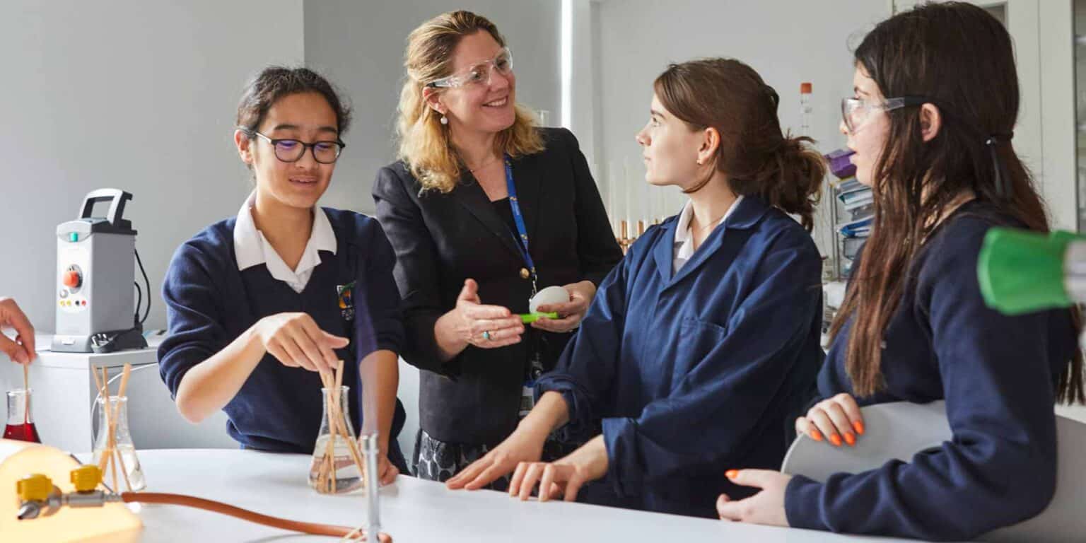 Students and teacher engaged in science experiment at school laboratory, focused on science education and innovative learning.
