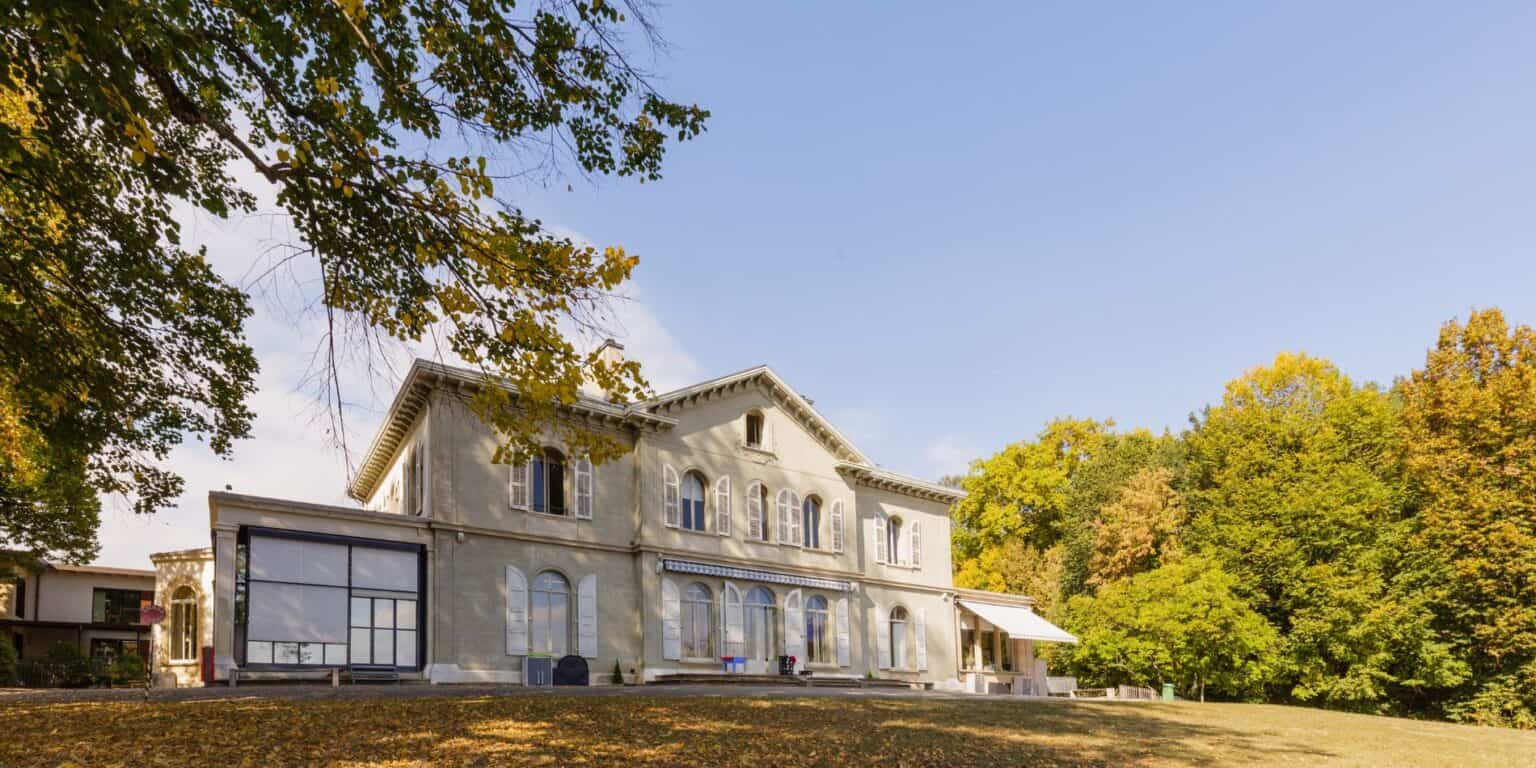 Elegant historic school building surrounded by colorful fall trees, excellent for international education.