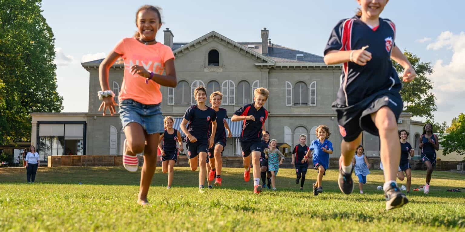 Bright children running outdoors in school uniforms during a fun outdoor activity at World Schools.