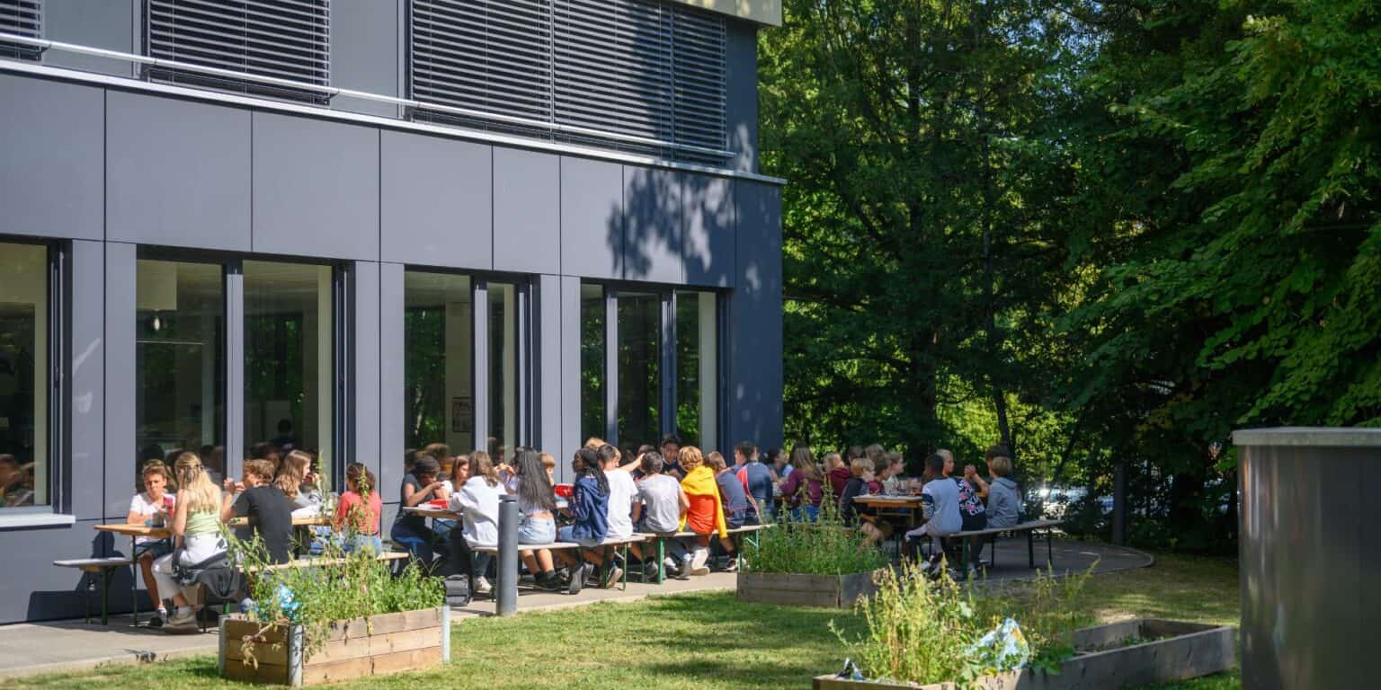 Comfortable outdoor dining area with students enjoying lunch at modern international school campus.