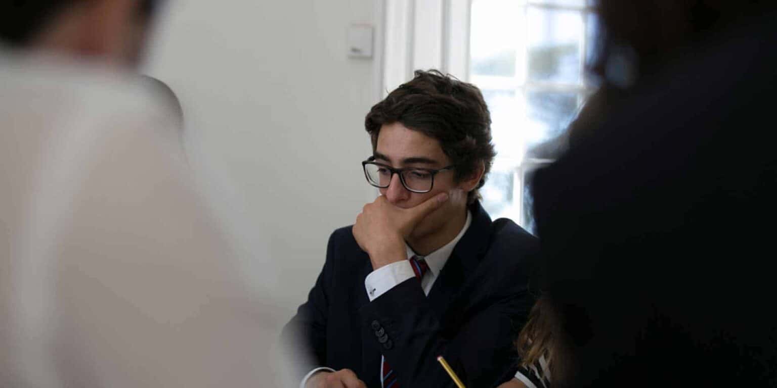 Young student deep in thought during an academic discussion or exam at World Schools.