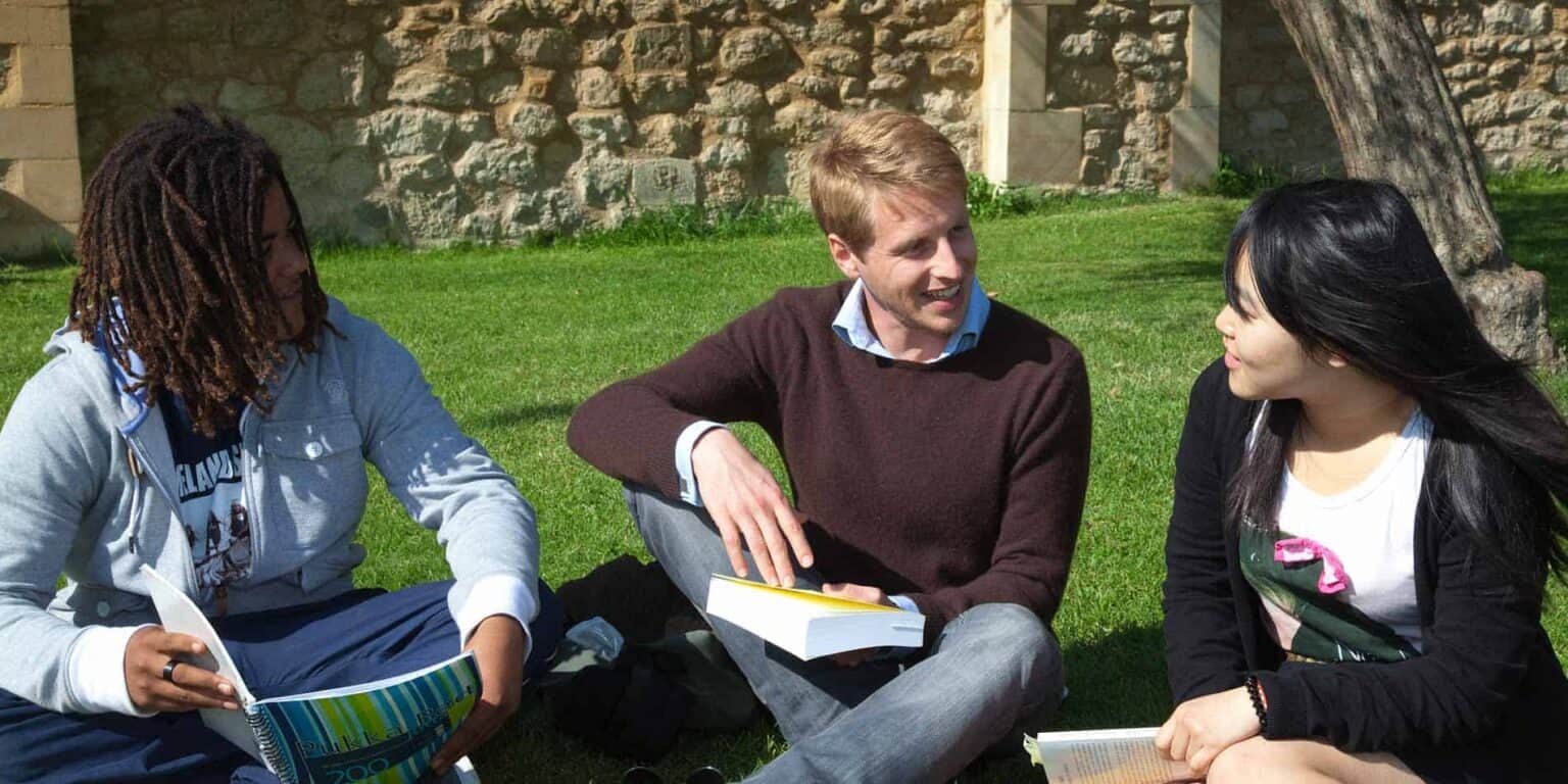 Students studying outdoors on a sunny day at an international school.