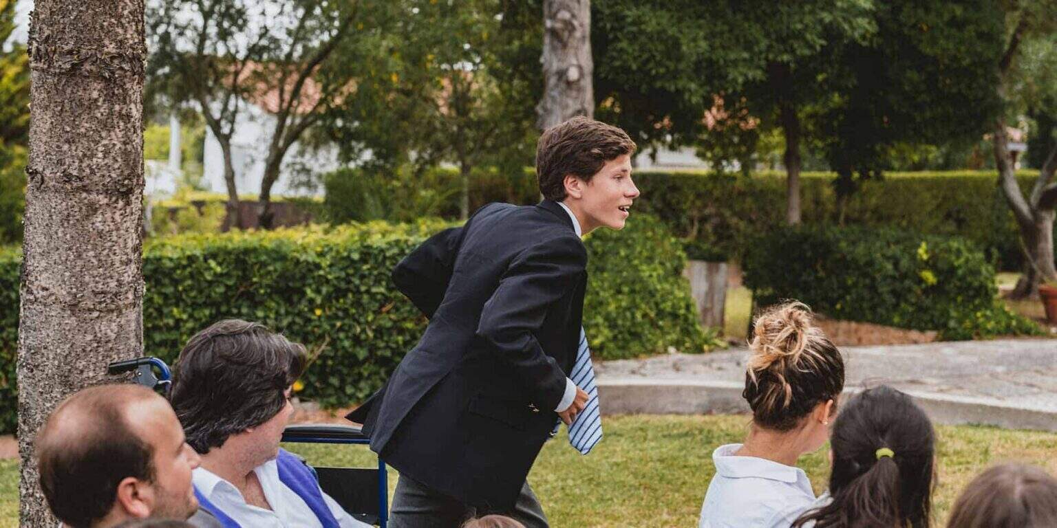 Engaging outdoor school event with students and teachers in lush green garden setting.