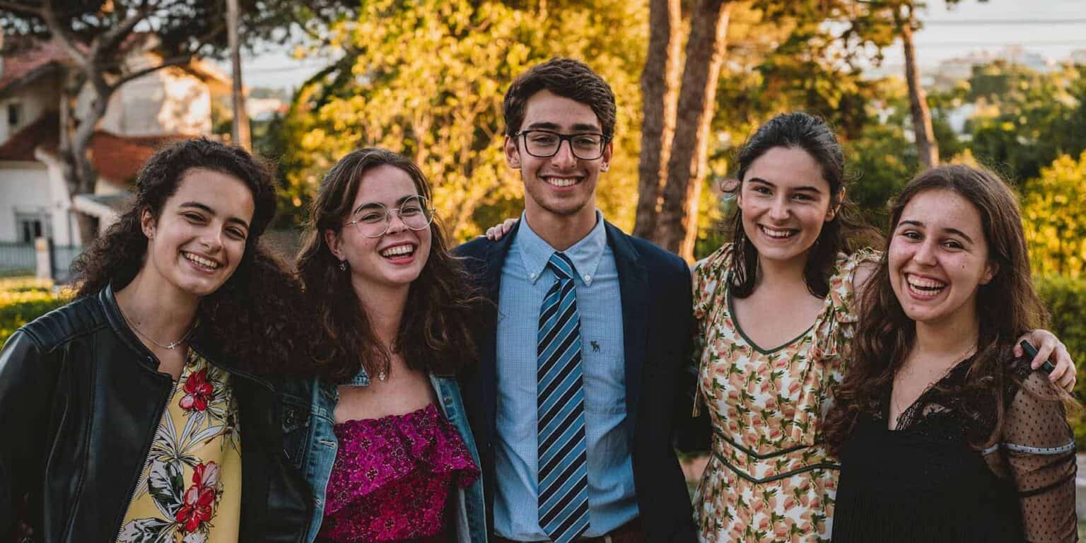 Diverse group of happy students outdoors in a park setting at a world school.