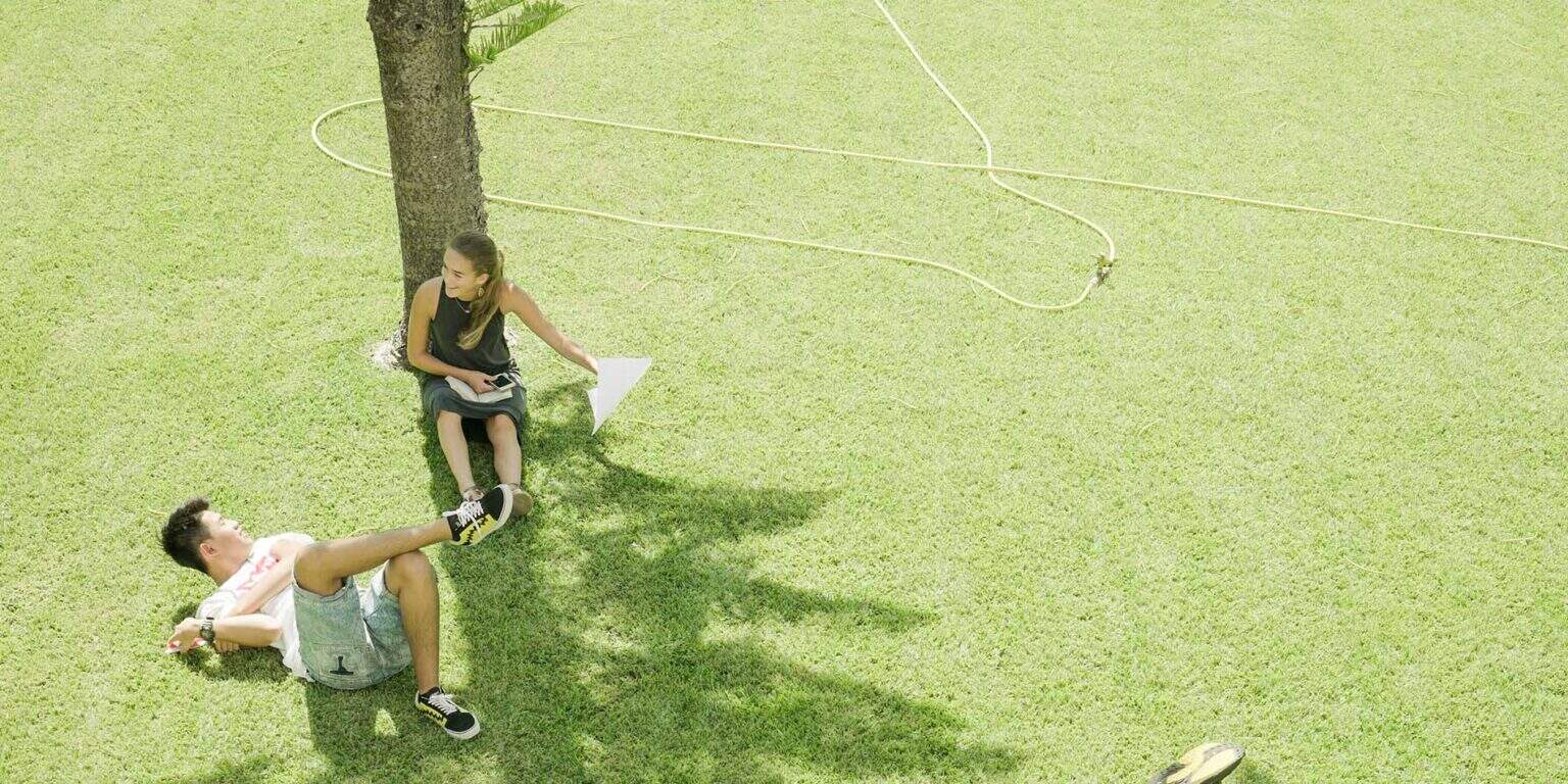 Young students relaxing and playing outdoors at a world school campus for educational excellence and global learning.