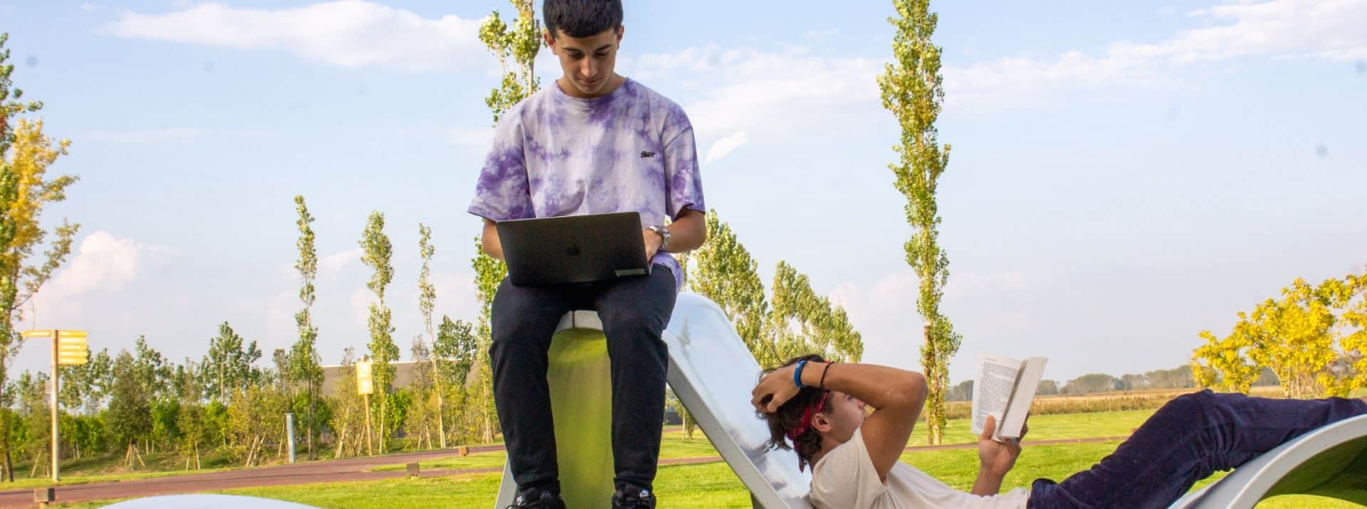 Young students studying outdoors on a sunny day at a world school.