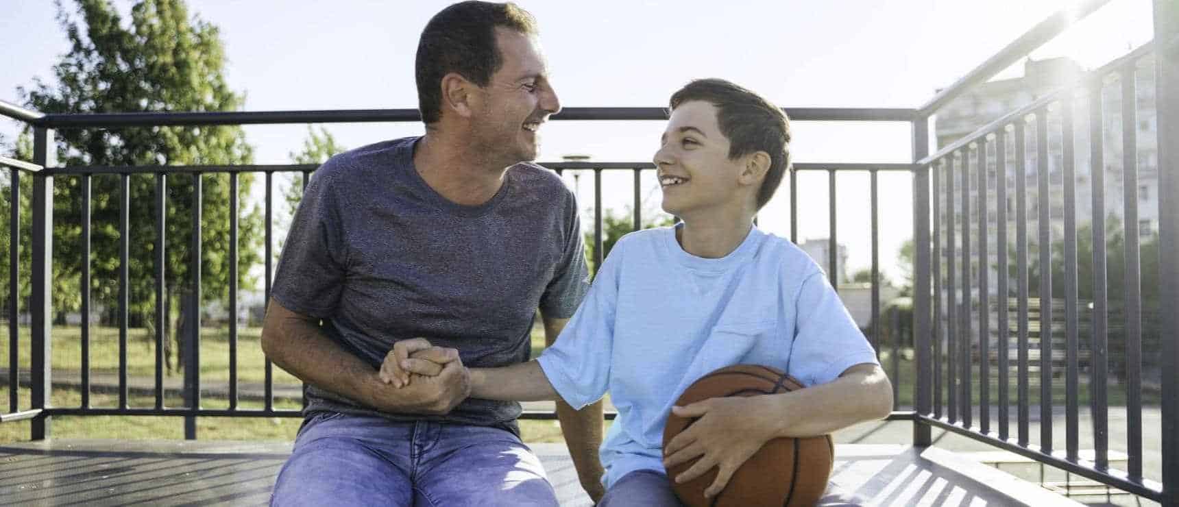 Happy father and son bonding during outdoor basketball at World Schools.