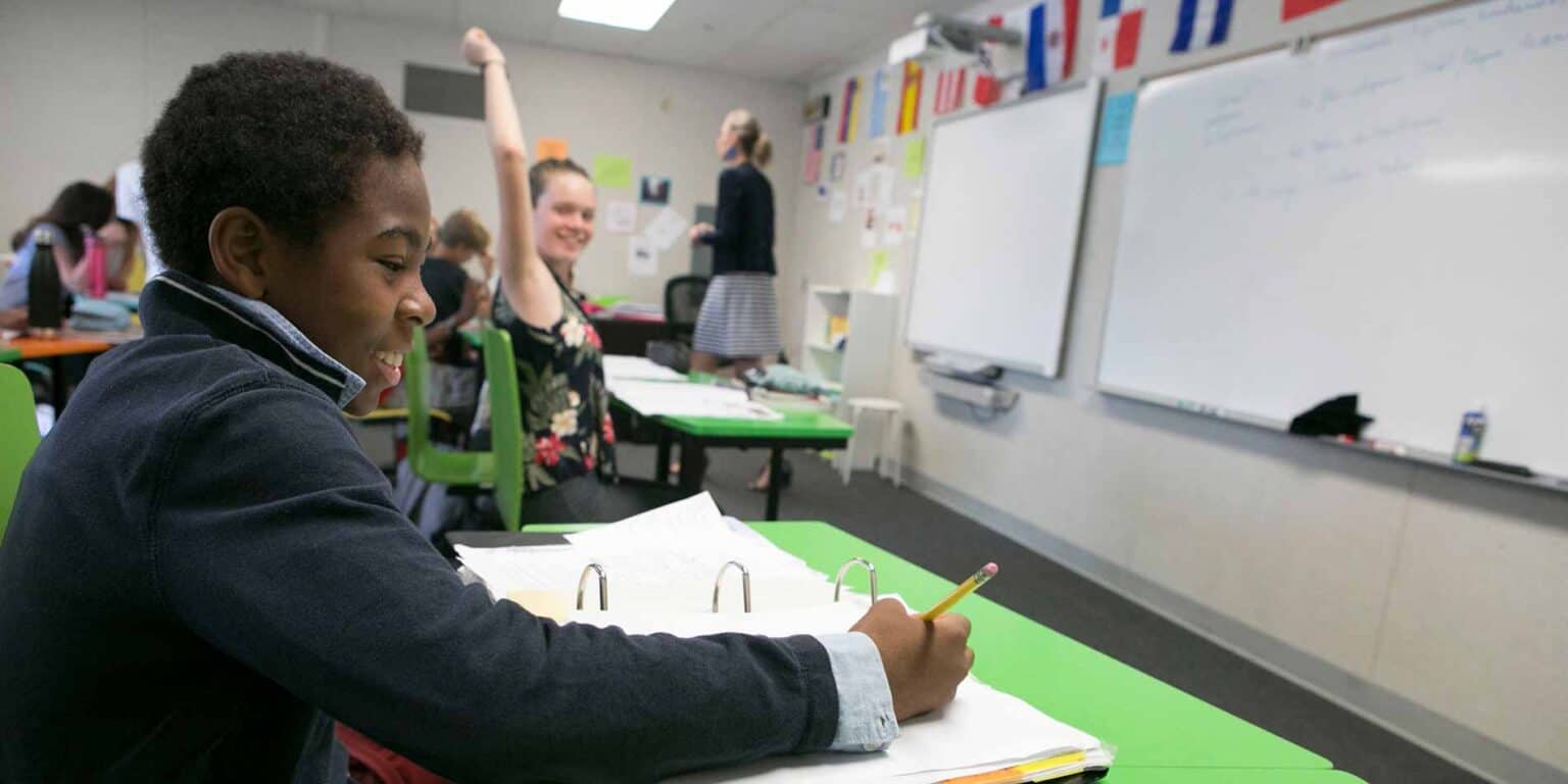 Colorful classroom with diverse students and teacher, fostering a positive learning environment.