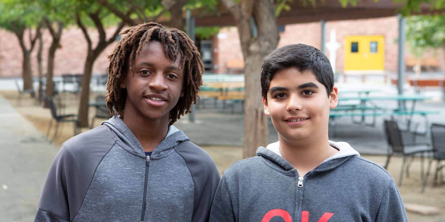Diverse students smiling outdoors at a world school, promoting global education and multicultural learning.