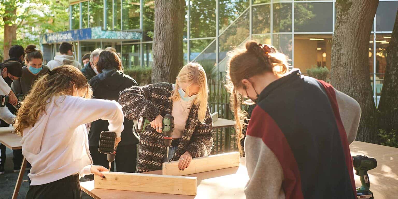 名門インターナショナルスクールで野外木工ワークショップに取り組む生徒たち。.