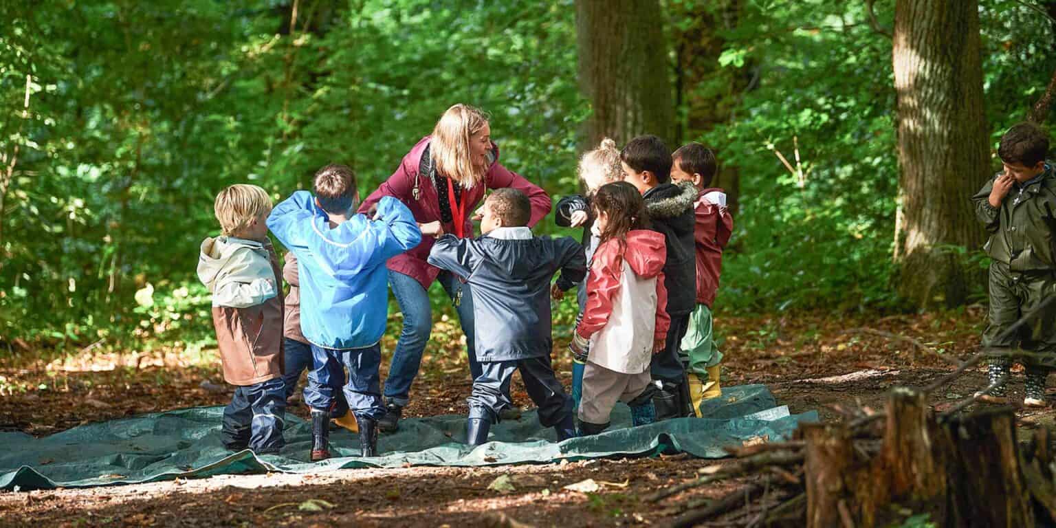 先生と一緒に森の中を冒険し、自然と環境教育について学ぶ子供たち。.