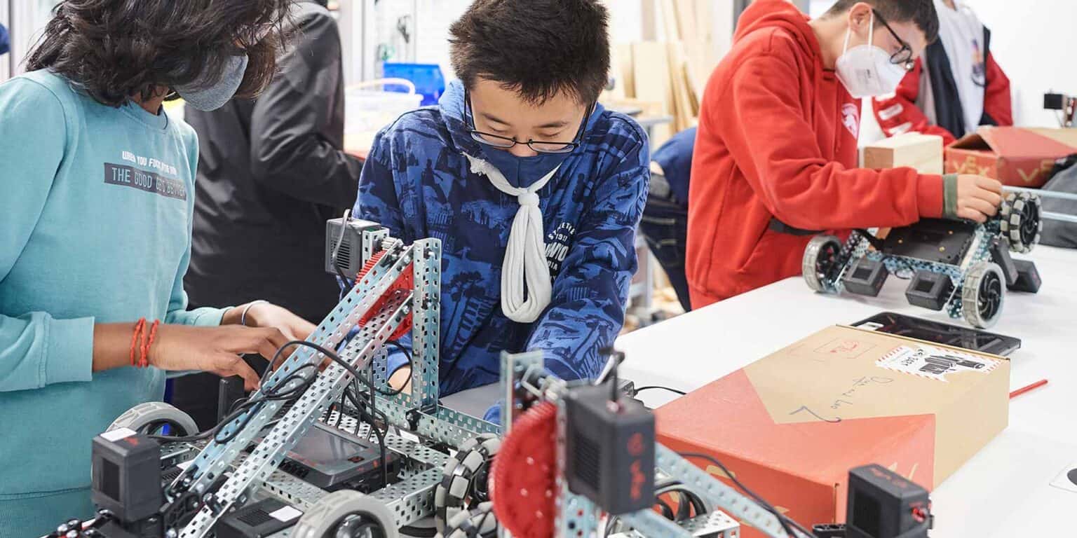世界的な学校のロボットワークショップでロボットを作る革新的な生徒たち。.