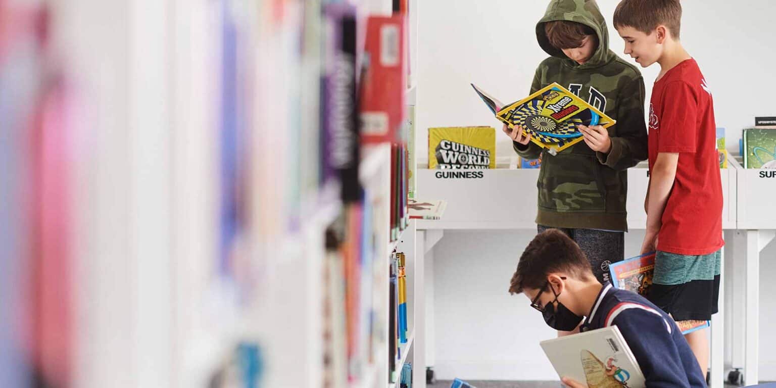 学校図書館で本を読む子供たち。.