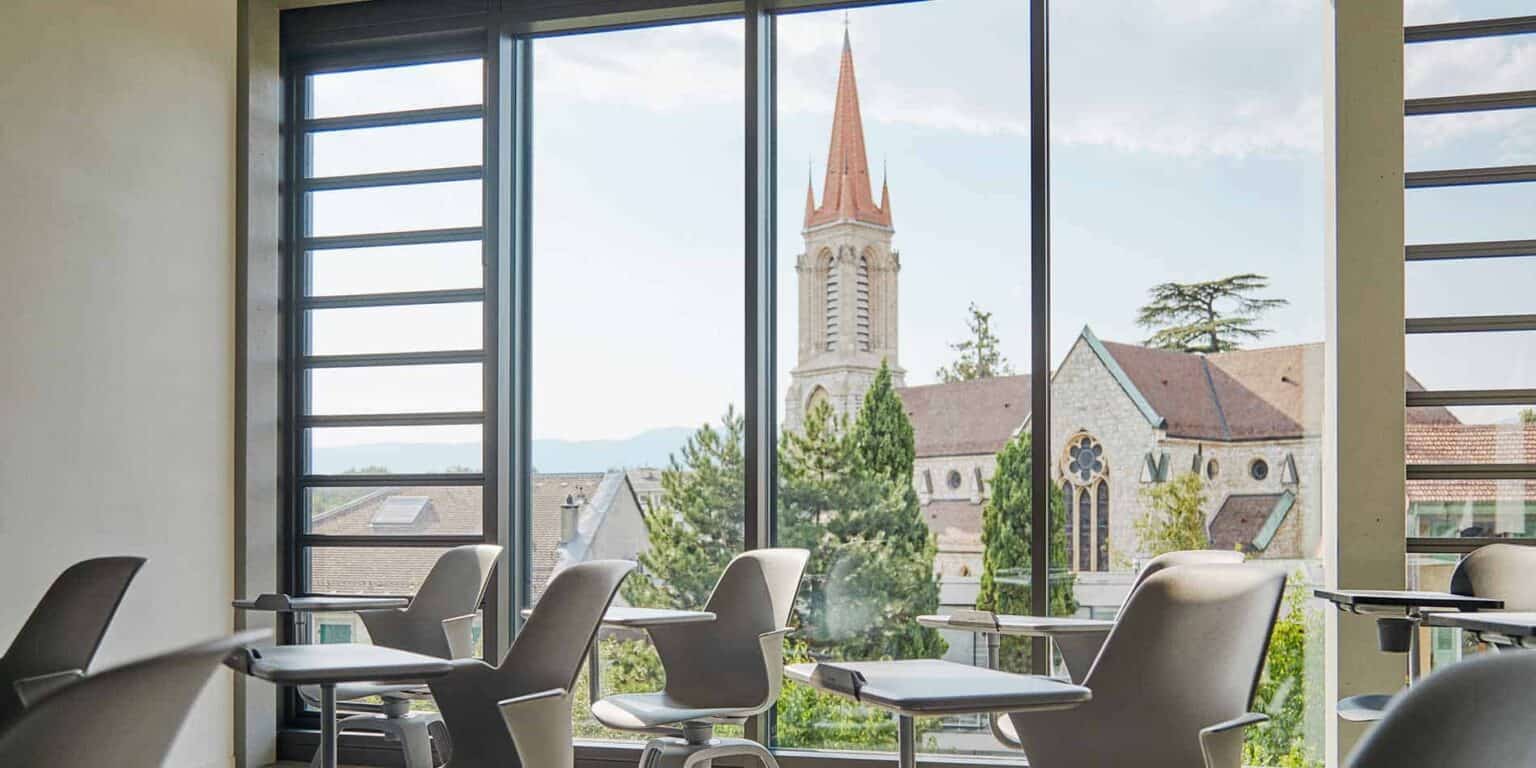 Modern classroom overlooking a historic church steeple, ideal for international school students.