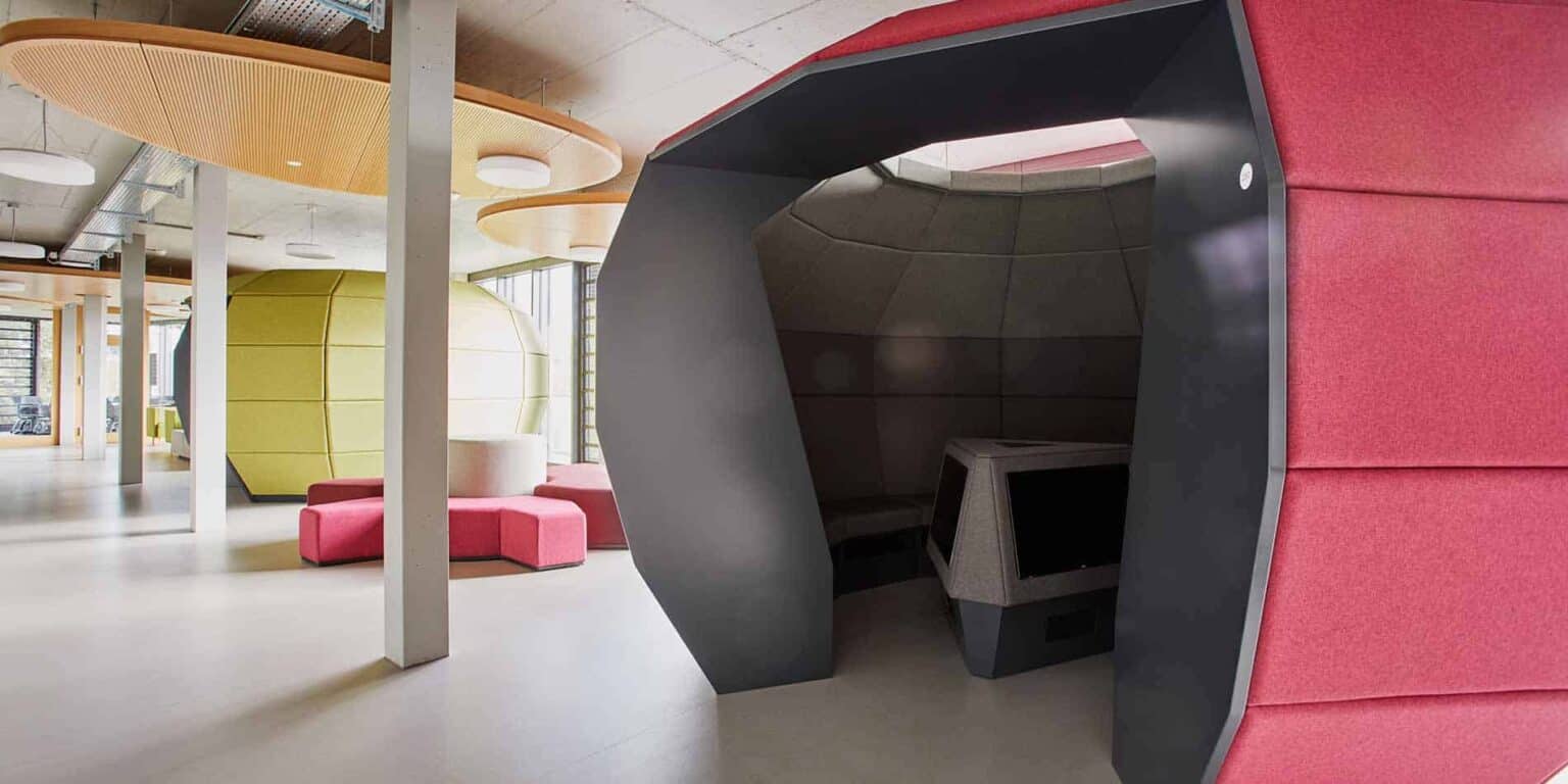 Modern school interior with colorful pods and study zones for innovative learning environments.