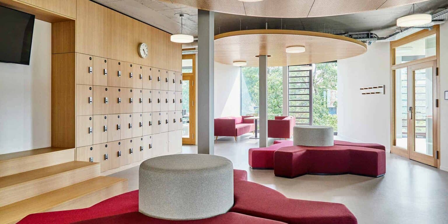 Bright, modern school lobby with lockers, comfortable seating, and large windows for a welcoming learning environment.