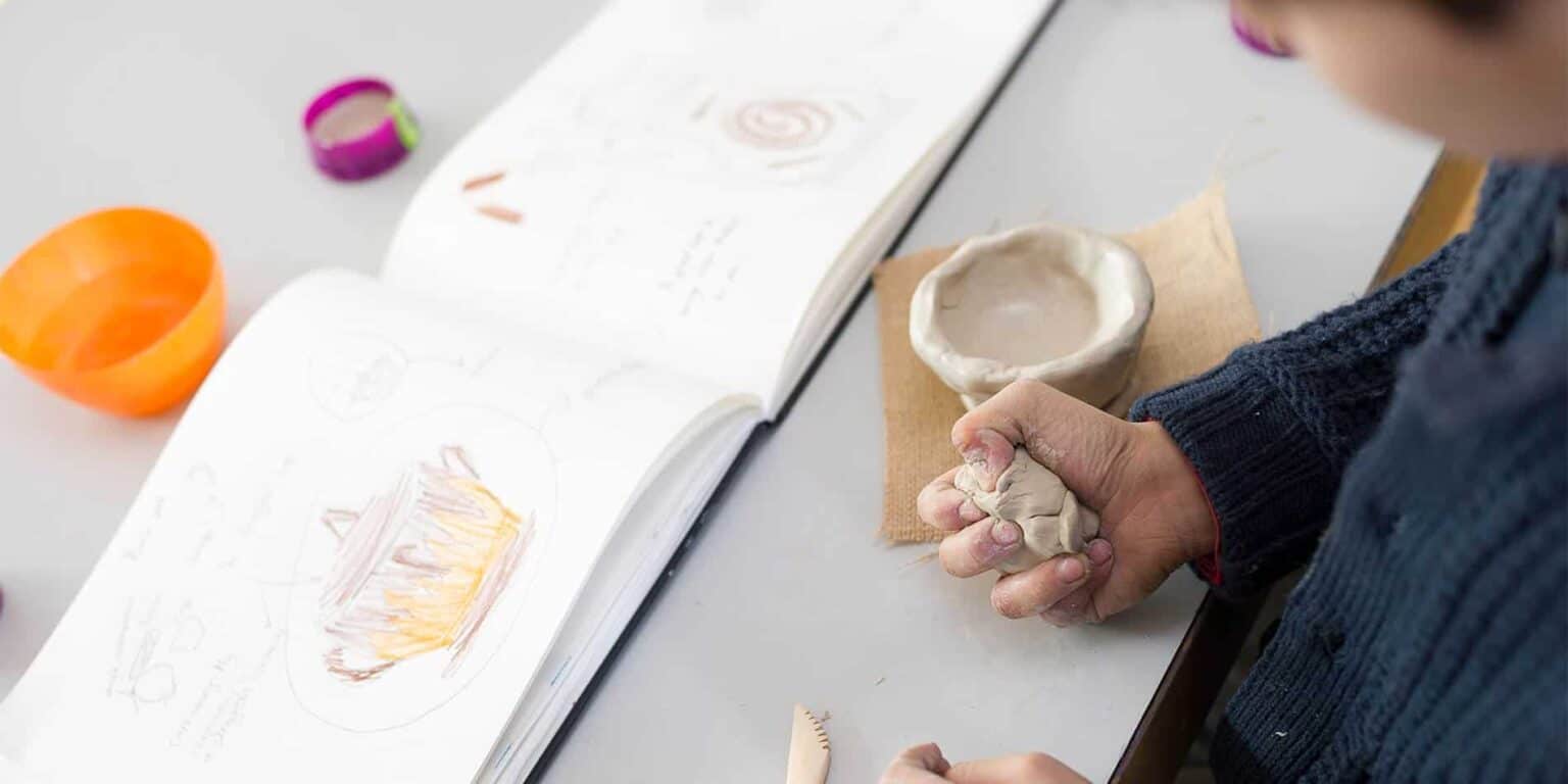 Clay modeling and sketching activities in a creative school classroom for kids.