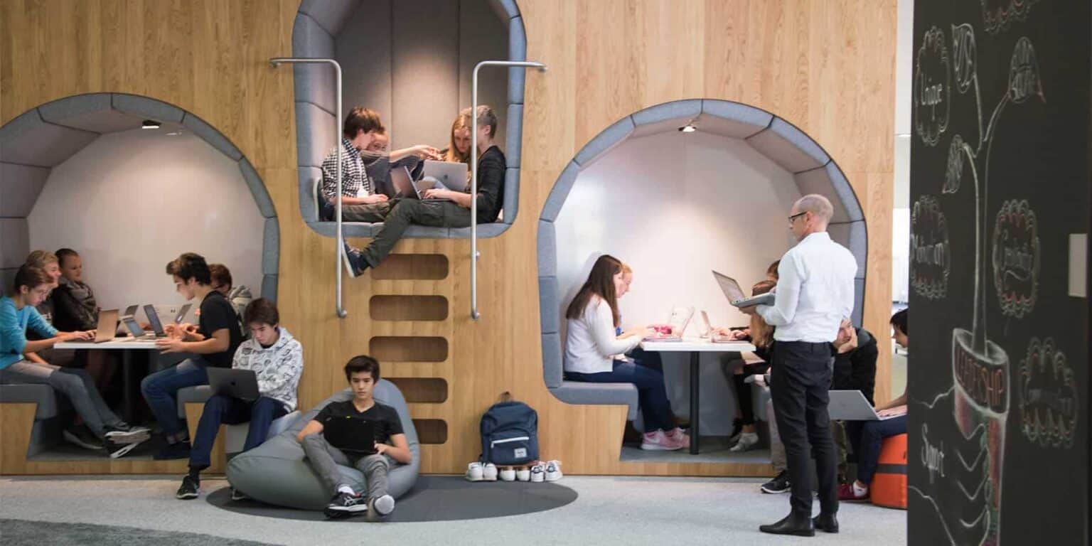 Students working collaboratively in a modern, innovative classroom at a world school with creative learning spaces.