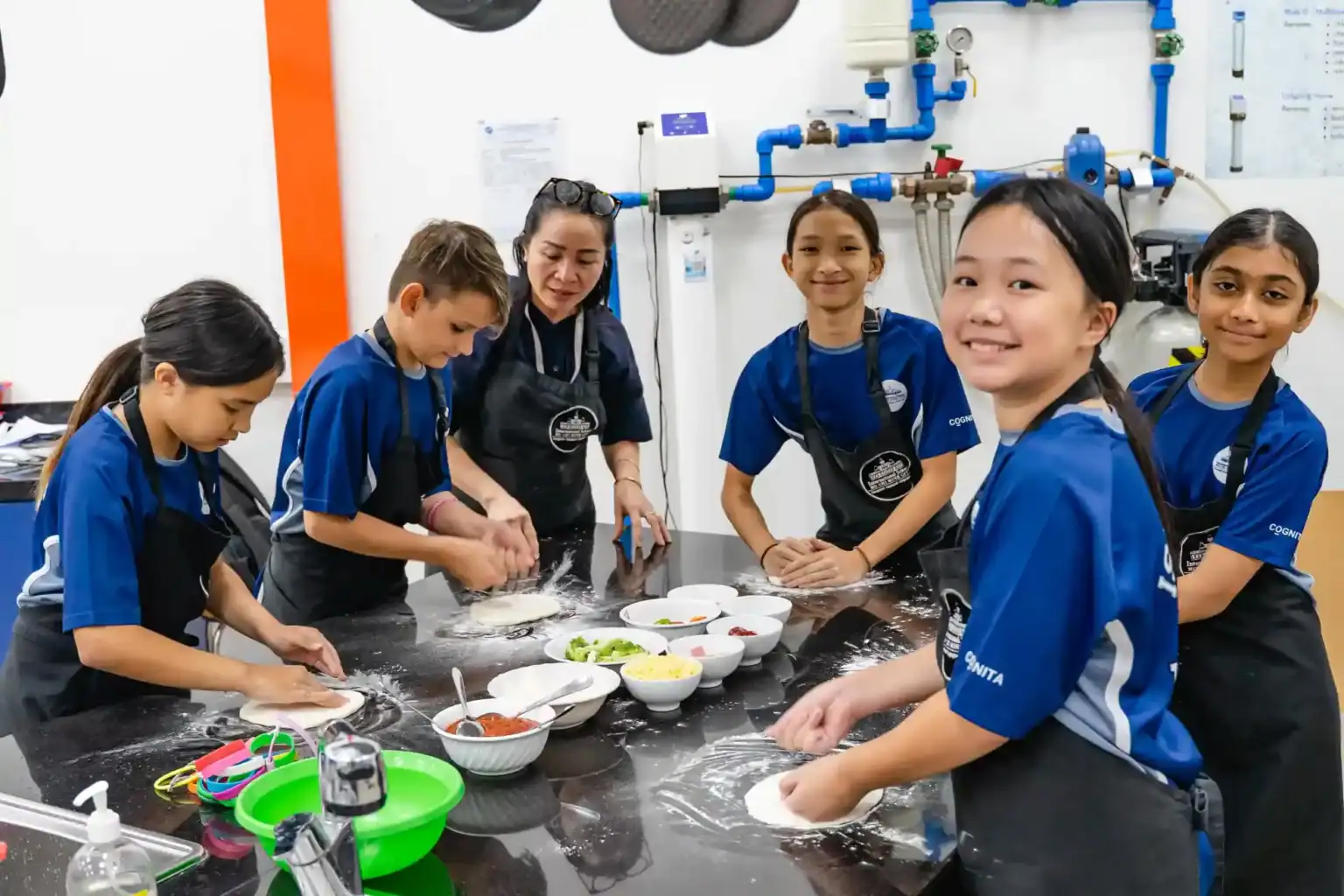 Children cooking in a classroom kitchen, learning culinary skills at a World School.