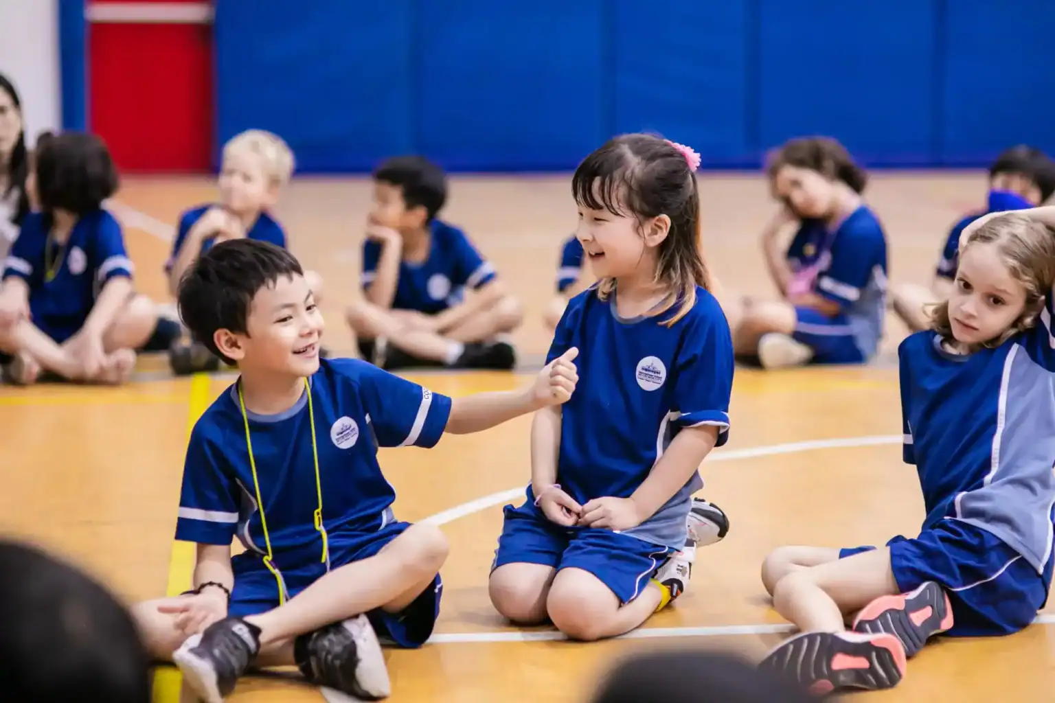 Happy children playing and learning at an international school in a gymnasium.