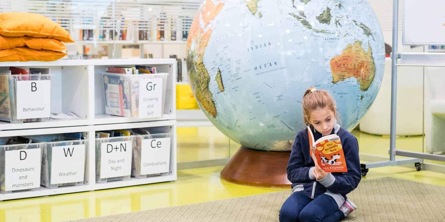 Colorful global classroom with a young girl reading a book, emphasizing international education and learning at World Schools.