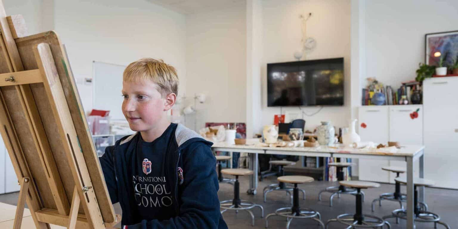 Bright young student engaging in art class at international school classroom environment.