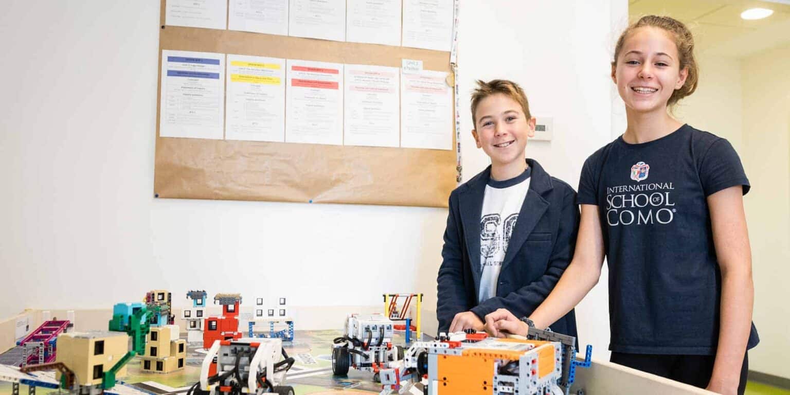 Innovative international school students presenting robotics project with LEGO bricks for STEM education.