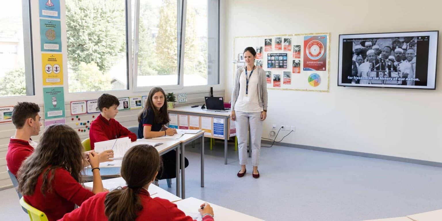 Modern classroom at World Schools with engaged students and digital learning tools.
