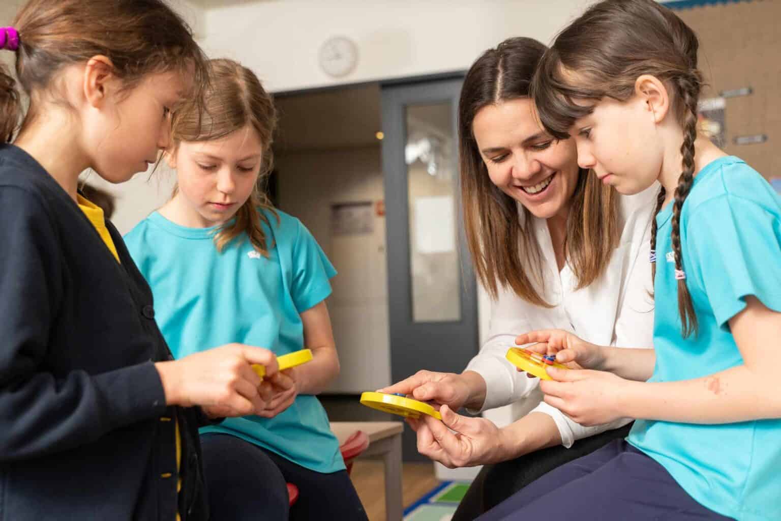 Bright young students engaged in an educational activity with teacher in a classroom setting.