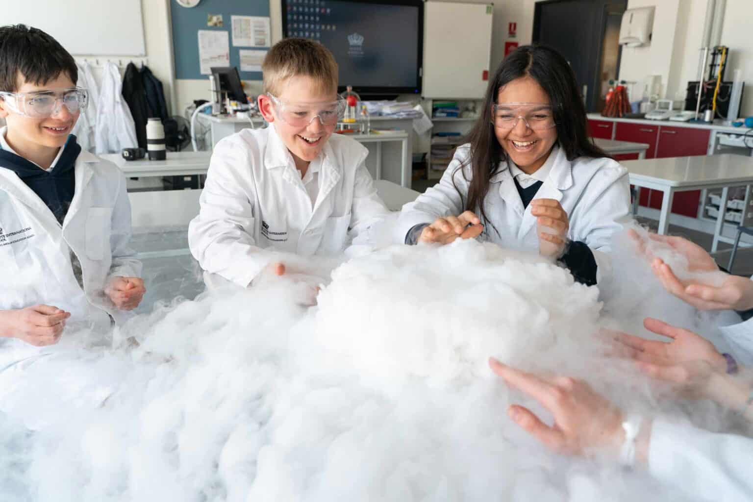 Kids conducting science experiments with dry ice in a classroom.