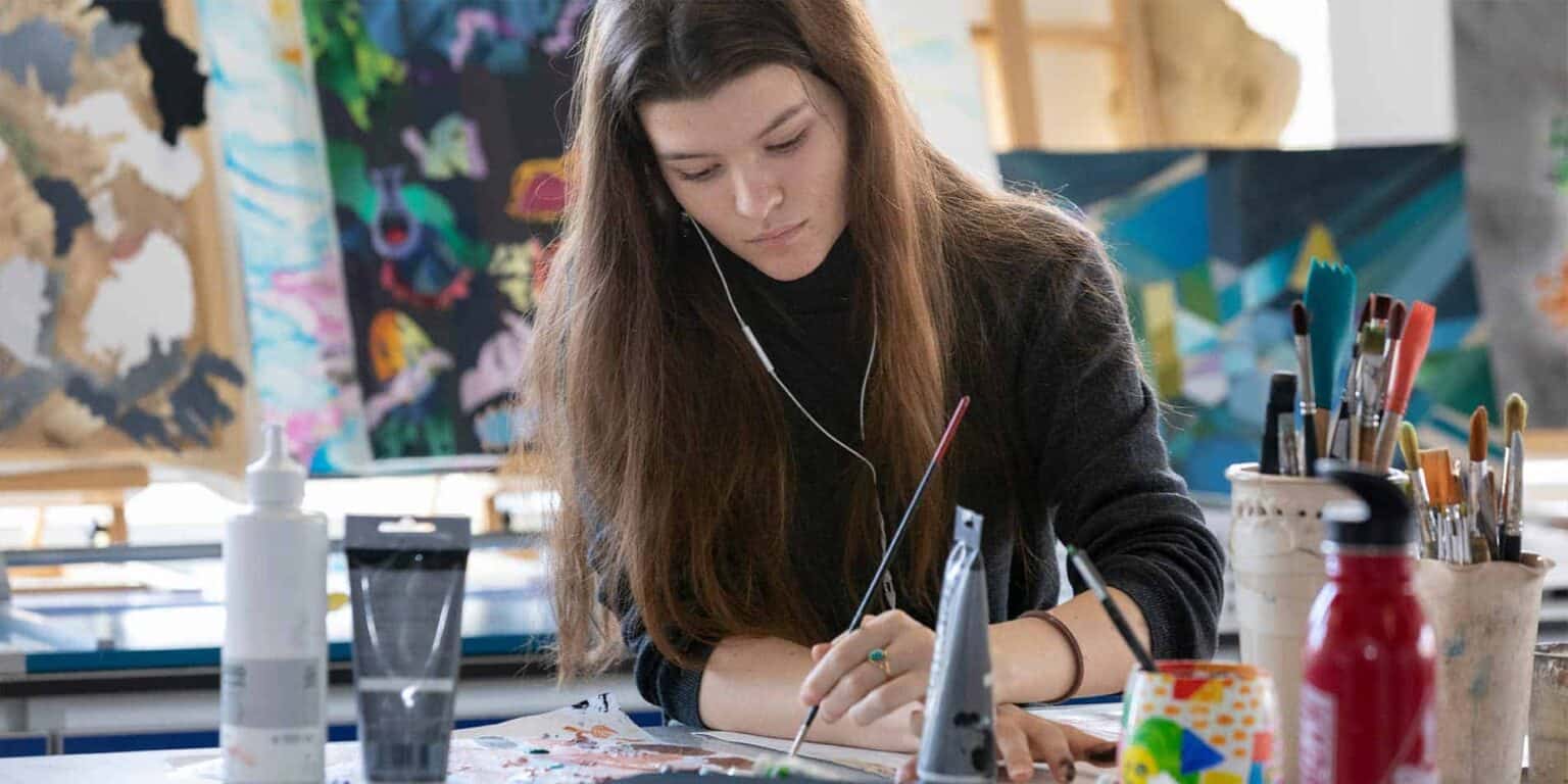 Creative student working on art project at World Schools art classroom.