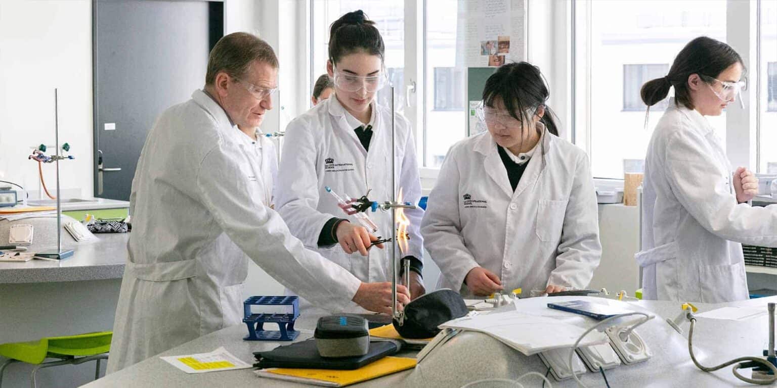 Highly focused students conducting chemistry experiments in a modern laboratory at World Schools.