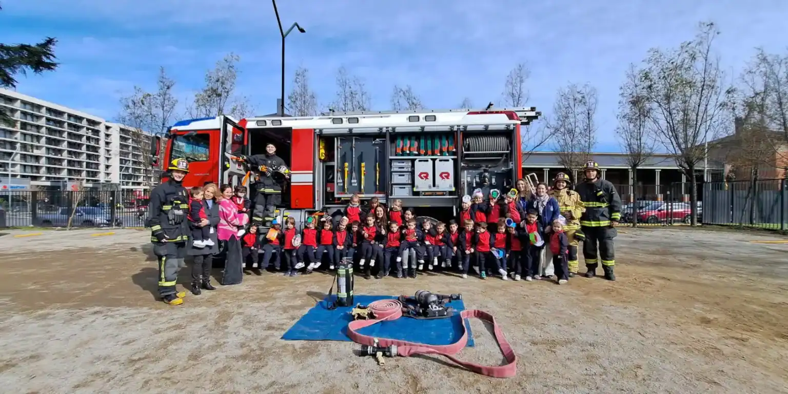 学校の防火訓練イベントで子どもたちに安全を教える消防士たち。.